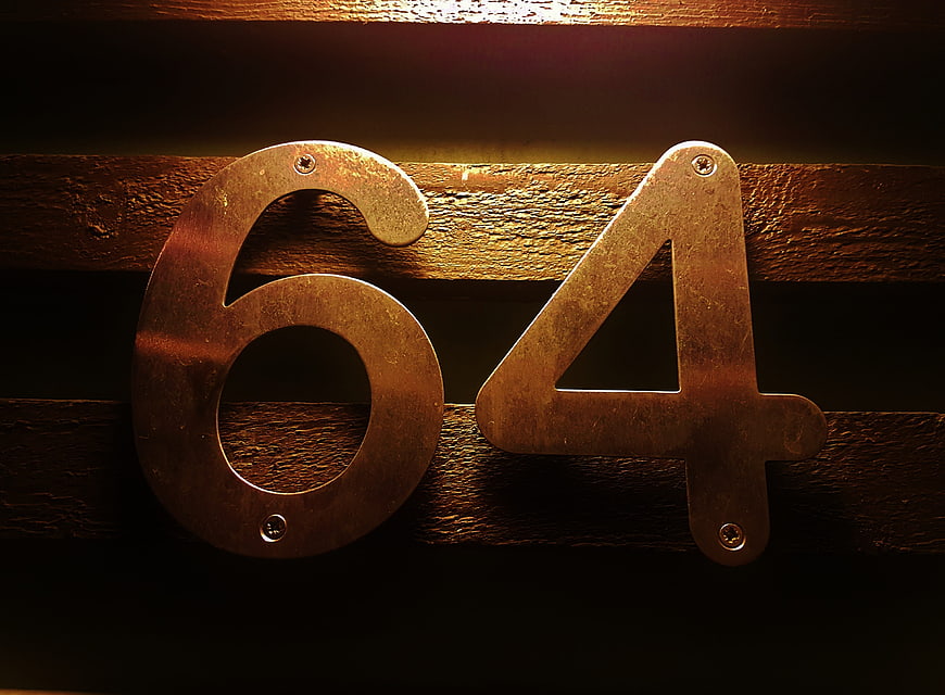 Vintage Metal Number 64 on Wooden Planks