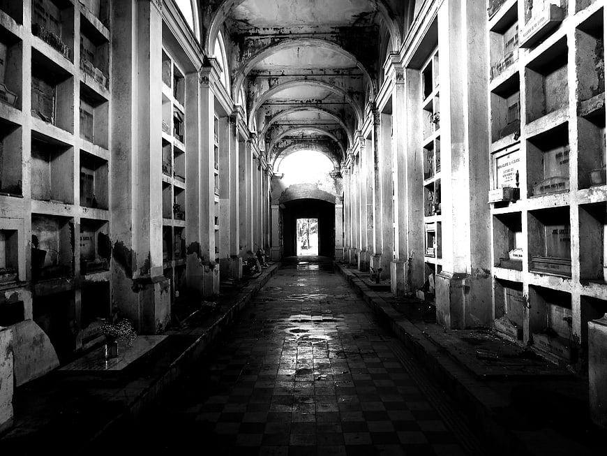 Black and white photo of a long underground cemetery corridor