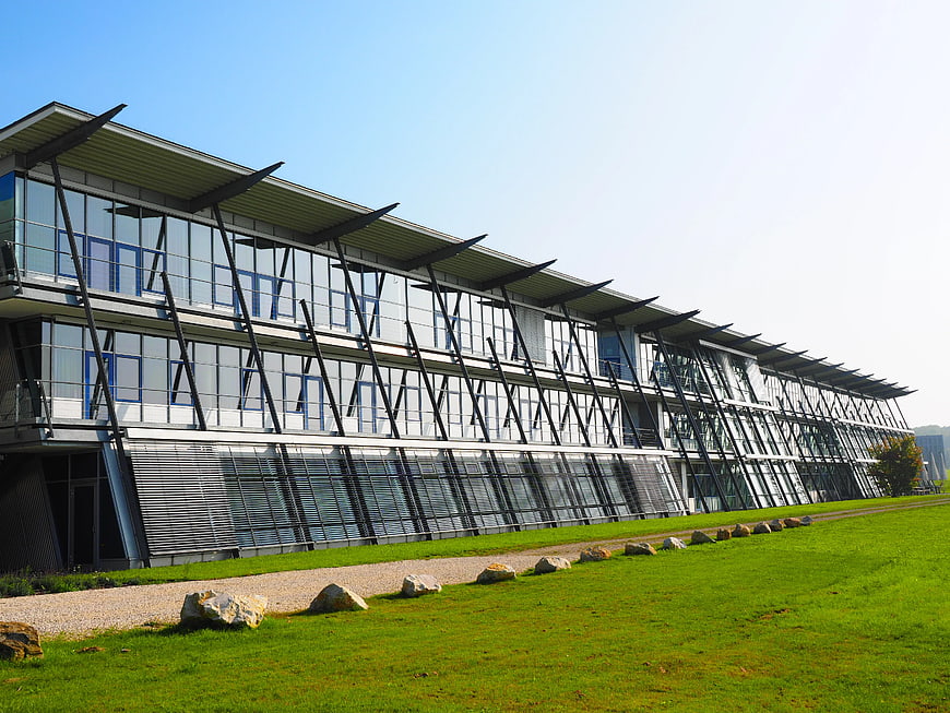 Modern Glass Office Building with Green Lawn and Blue Sky