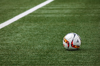 Soccer ball on green artificial turf with white line