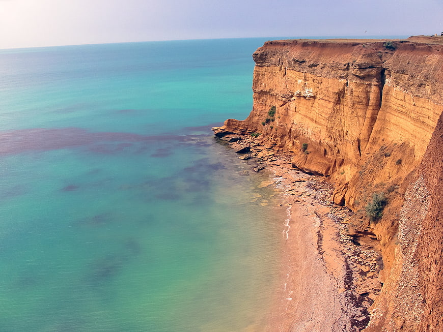 Aerial View of Red Cliffs and Turquoise Ocean Coastline