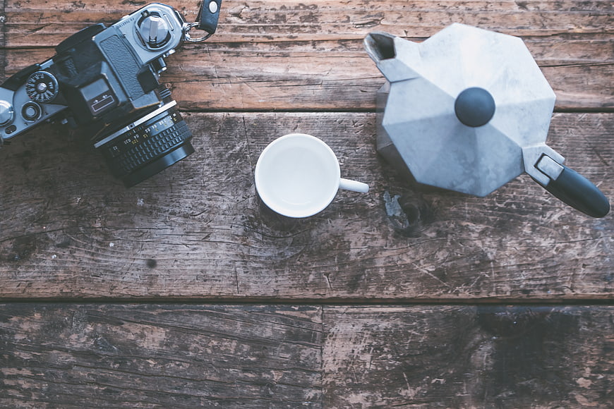 Vintage camera and moka pot on rustic wooden table