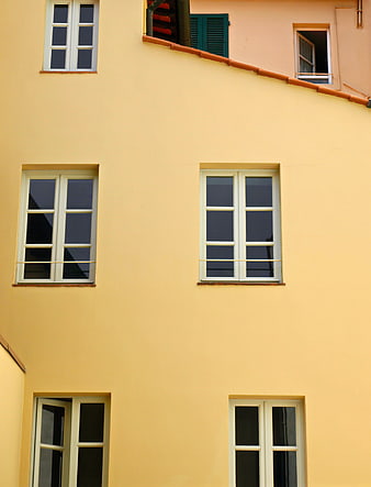 Yellow building facade with white windows and architectural details
