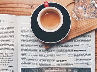 Top view of coffee cup on newspaper and wooden table