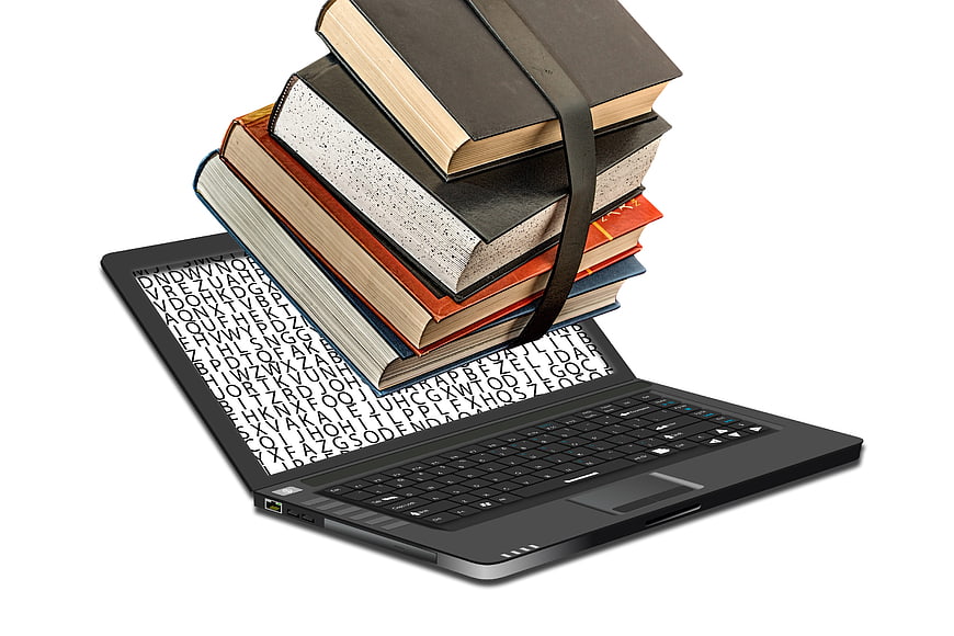 Stack of books on laptop screen with text background