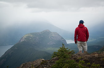 Hiker in Red Jacket Overlooking Misty Mountain Ridge