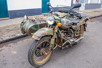 Vintage military motorcycle with sidecar in camouflage