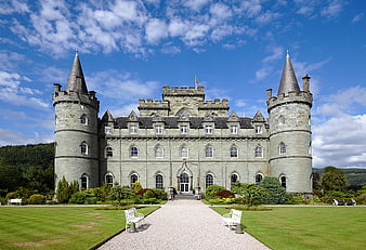 Historic Scottish Castle Facade With Conical Turrets And Manicured Gardens