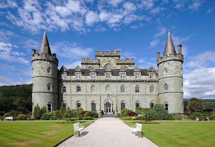 Historic Scottish Castle Facade With Conical Turrets And Manicured Gardens