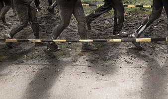 Muddy legs running through obstacle course race