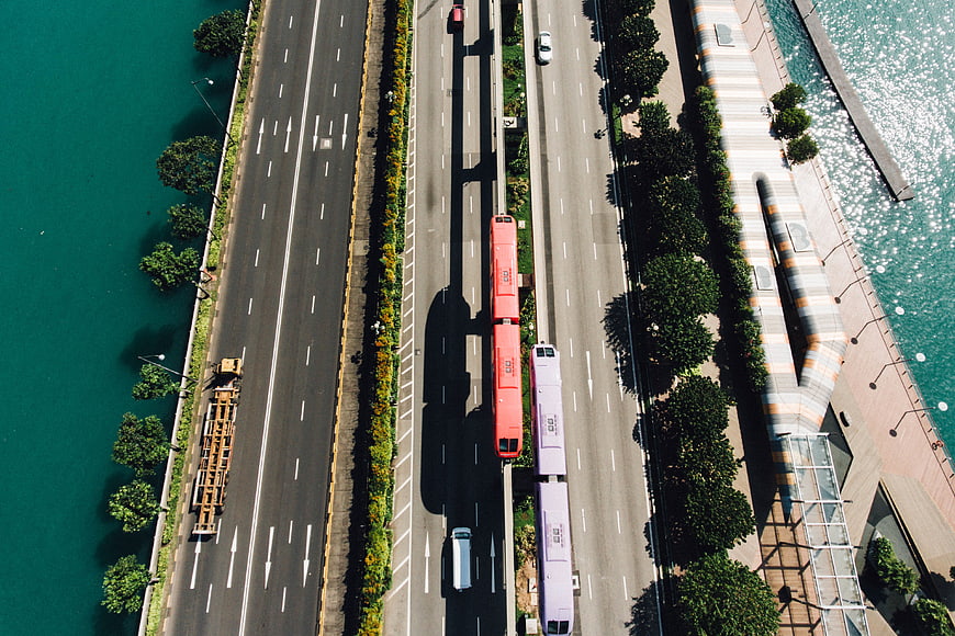 Aerial view of coastal highway with red and white trains