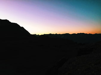 Silhouette of mountain range against colorful twilight sky