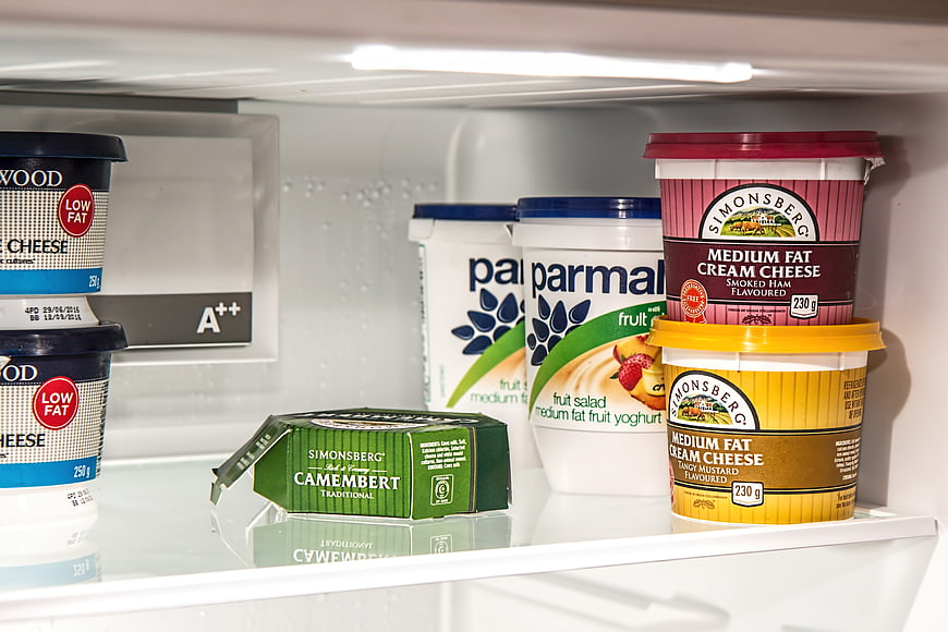 Dairy products and cheese inside a refrigerator shelf