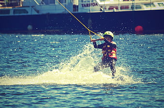 Child water skiing with helmet and life jacket