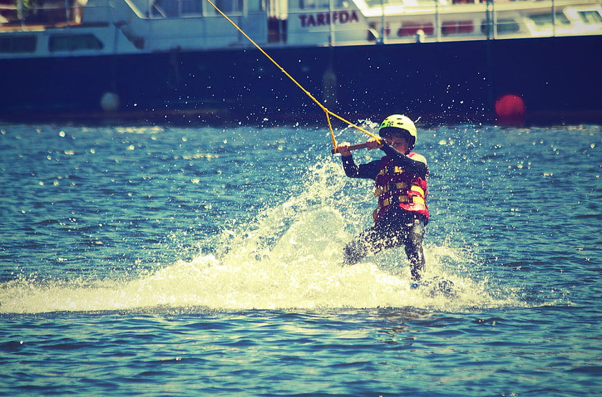 Child water skiing with helmet and life jacket