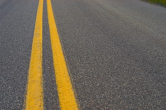 Close-up of Double Yellow Lines on Asphalt Road