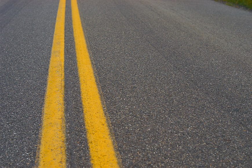 Close-up of Double Yellow Lines on Asphalt Road