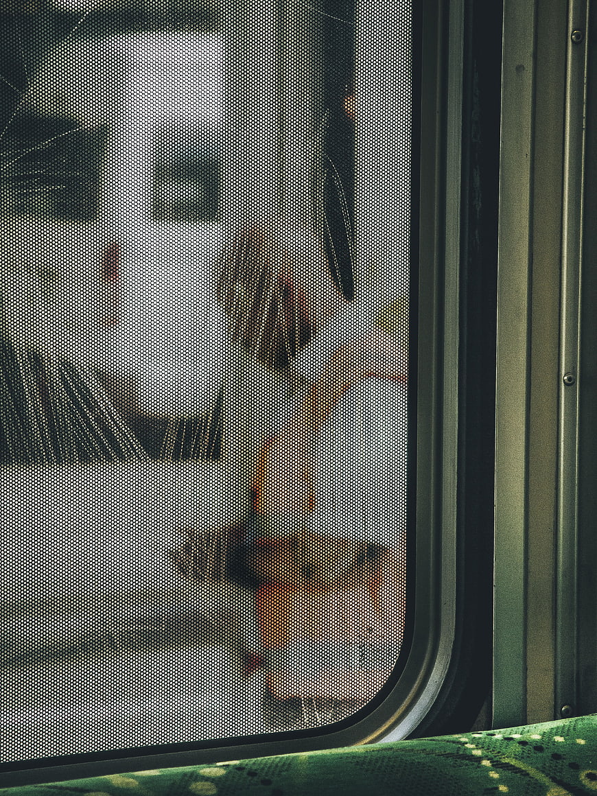 Blurred View of People Through Train Window Mesh