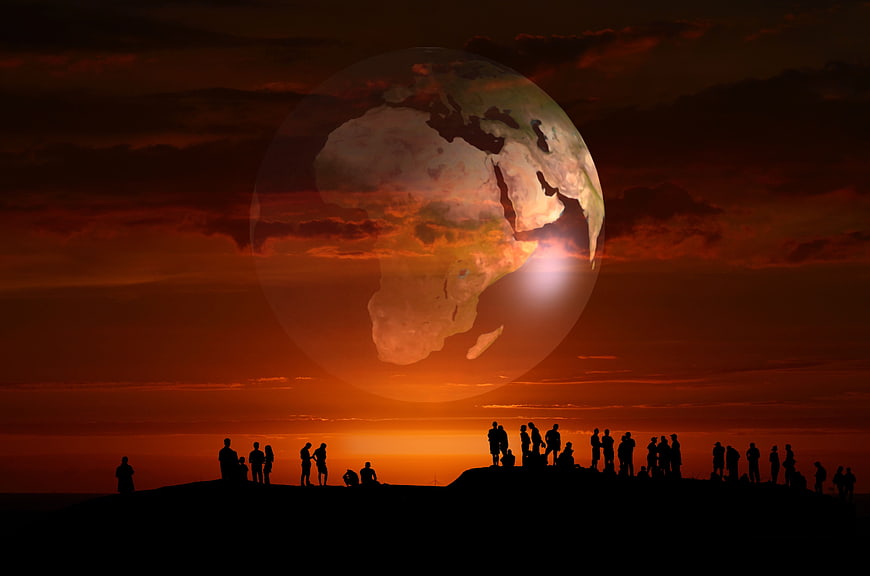 Silhouetted Crowd Watching Giant Earth Globe at Dramatic Sunset