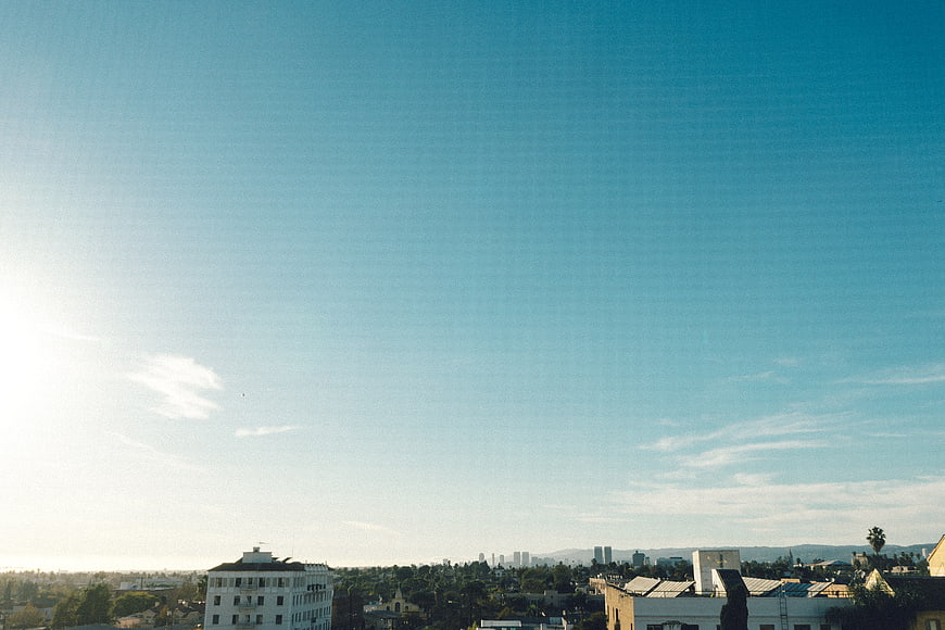 Wide City Skyline Under Vast Blue Sky with Film Grain
