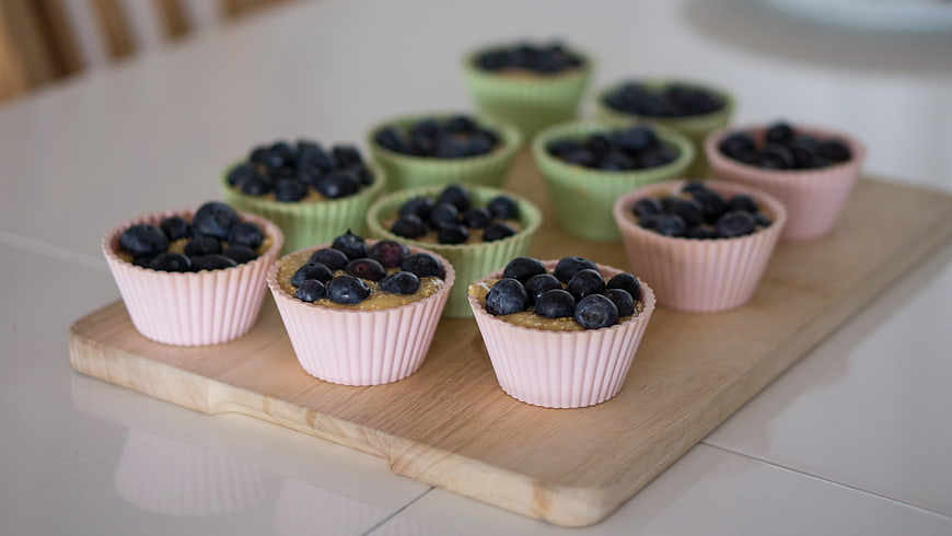 Fresh Blueberry Muffins in Silicone Cups on Wooden Board