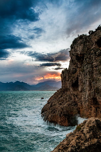 Dramatic Sunset Over Rocky Coastal Cliffs and Ocean