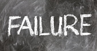 The word failure written in white chalk on a dark blackboard