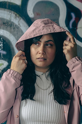 Woman in Pink Hoodie Against Graffiti Wall