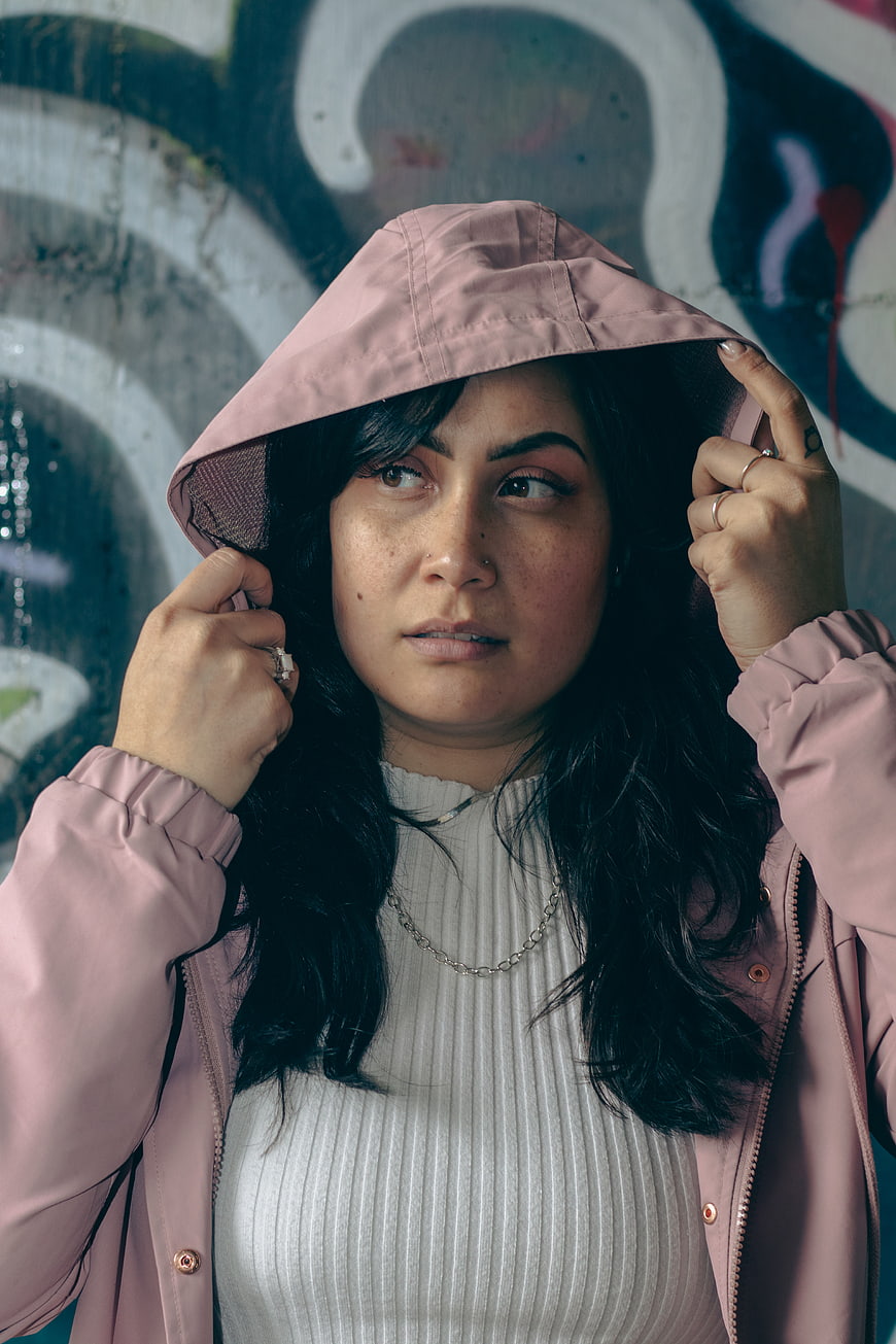 Woman in Pink Hoodie Against Graffiti Wall