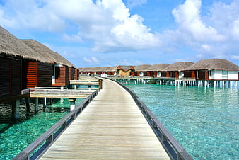 Tropical Overwater Bungalows Connected By Wooden Boardwalk In Maldives