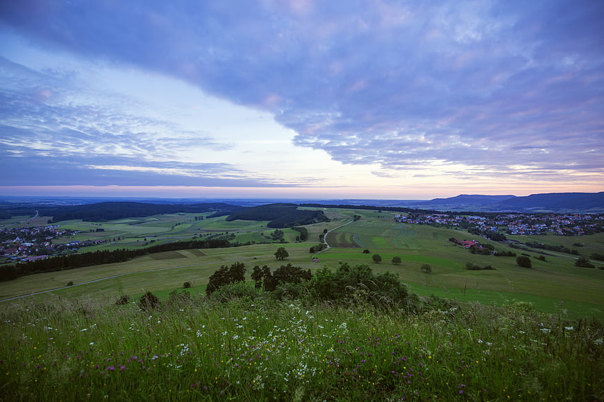 Panoramic View of Rolling Green Hills and Village at Dusk