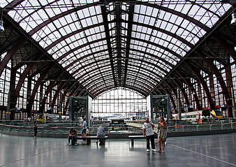 Wide angle view of a grand train station hall with arched roof