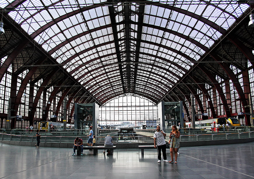 Wide angle view of a grand train station hall with arched roof