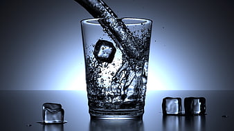 Water Pouring Into Glass With Ice Cubes On Dark Blue Background