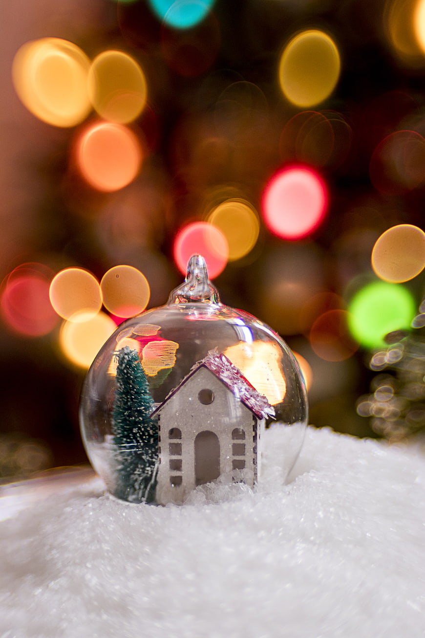 Christmas bauble with miniature house and tree in snow