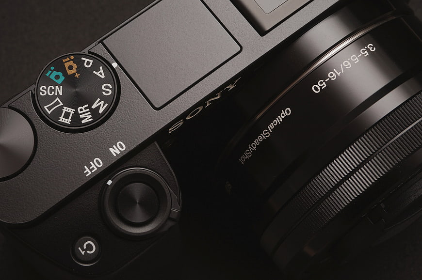 Close-up of black Sony mirrorless camera top dial and lens