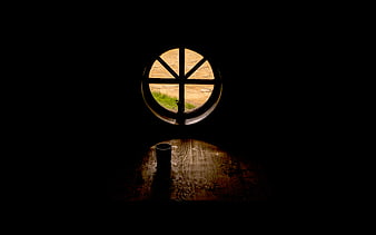 Dark room with round window and wooden table