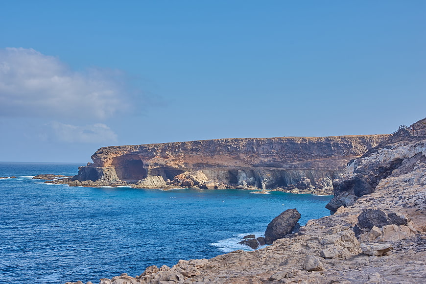 Dramatic rocky coastline with sea caves and blue ocean