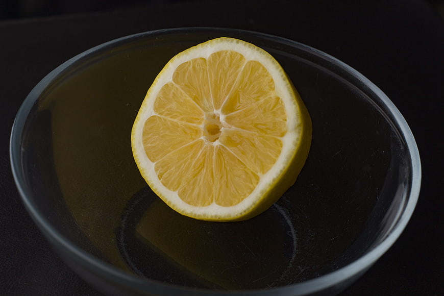 Sliced Lemon on Dark Plate