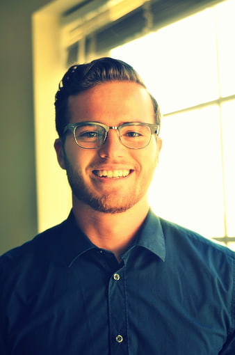 Portrait of smiling young man with glasses in office