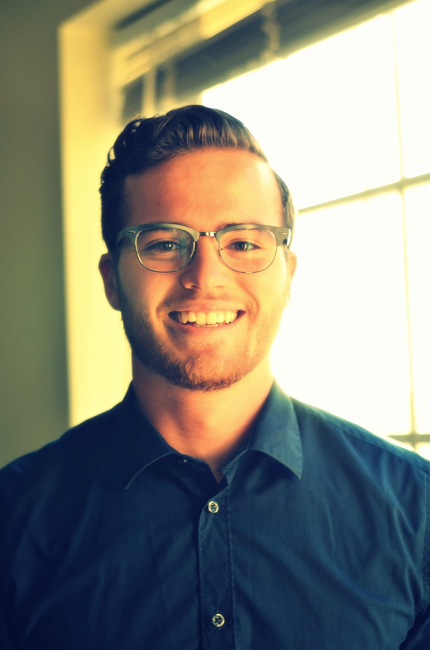 Portrait of smiling young man with glasses in office