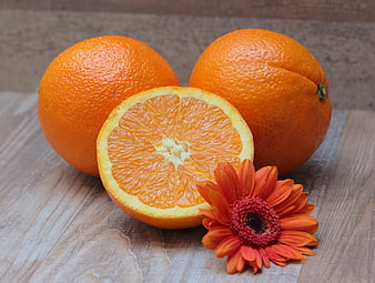 Fresh Oranges and Orange Gerbera Daisy on Rustic Wooden Table