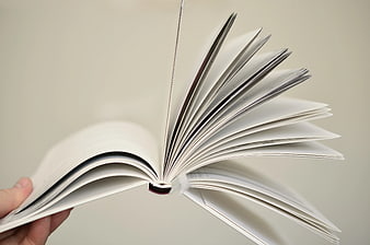 Hand Flipping Pages of Open Book