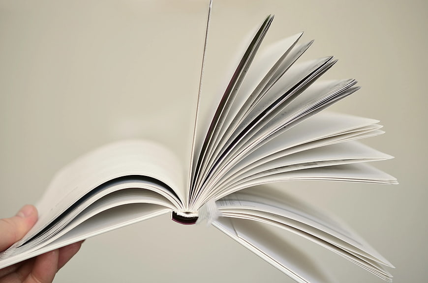 Hand Flipping Pages of Open Book