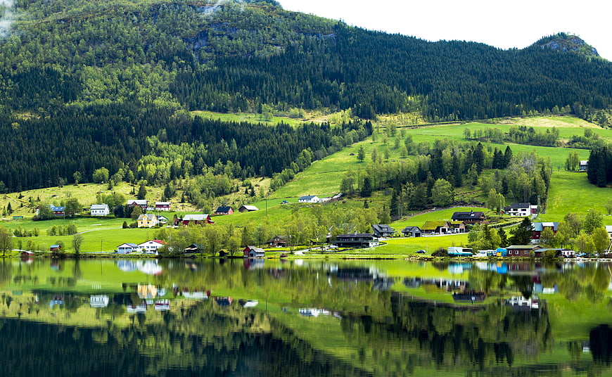 Scenic Norwegian village with lake reflections and green mountains