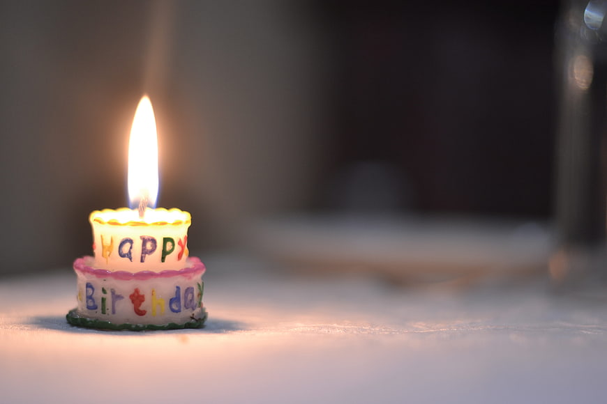 Lit Happy Birthday Cake Candle on Table