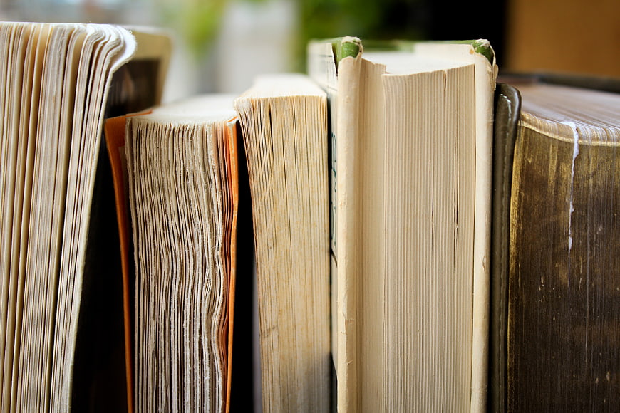 Close-up of old book spines and pages on a shelf