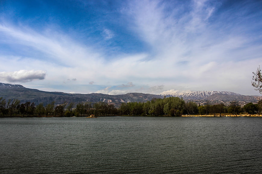 Serene Lake Landscape with Snow-Capped Mountains and Blue Sky