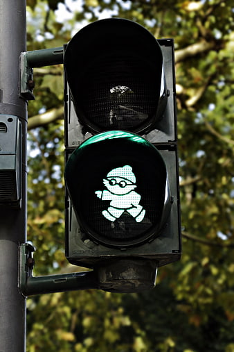 Green pedestrian traffic light with whimsical Mainzelmännchen figure
