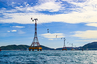 Yellow Cable Car Towers Spanning Blue Ocean Water